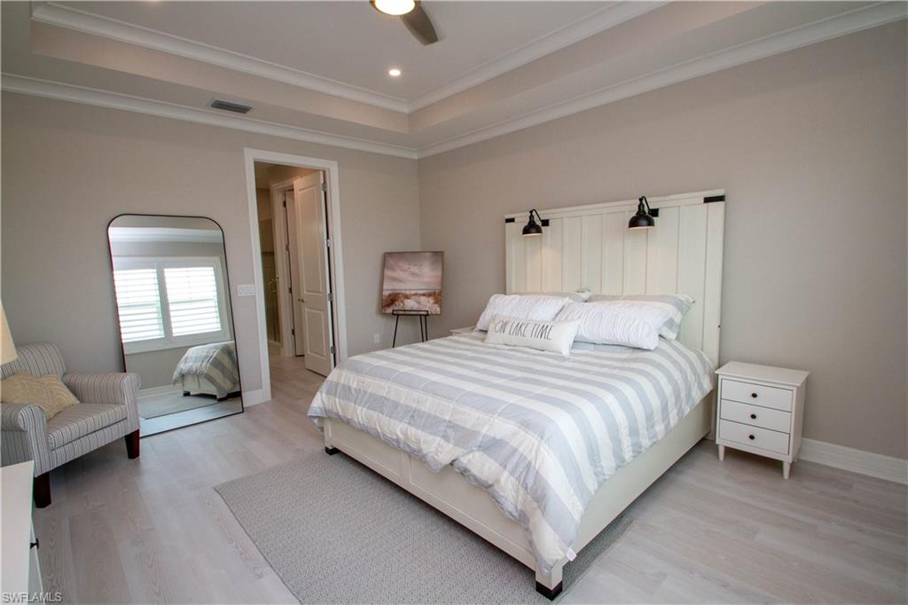 251 Indies Drive East, Unit 202 Naples, FL 34114 - Photo 30 of 48 a bedroom with a bed a couch and dresser