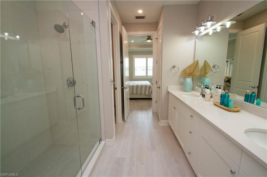 251 Indies Drive East, Unit 202 Naples, FL 34114 - Photo 36 of 48 a spacious bathroom with a double vanity sink mirror and shower