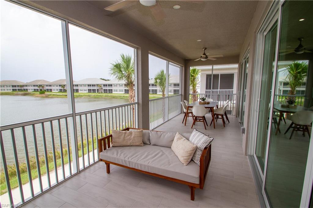 251 Indies Drive East, Unit 202 Naples, FL 34114 - Photo 37 of 48 a living room with furniture tv and a floor to ceiling window