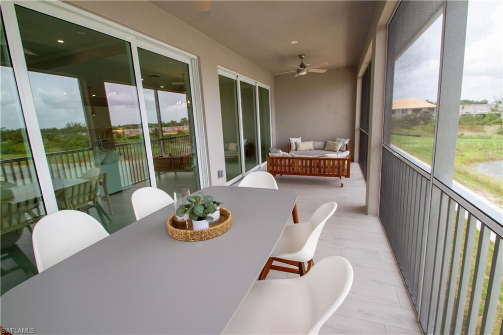 251 Indies Drive East, Unit 202 Naples, FL 34114 - Photo 38 of 48 a living room with furniture and a floor to ceiling window
