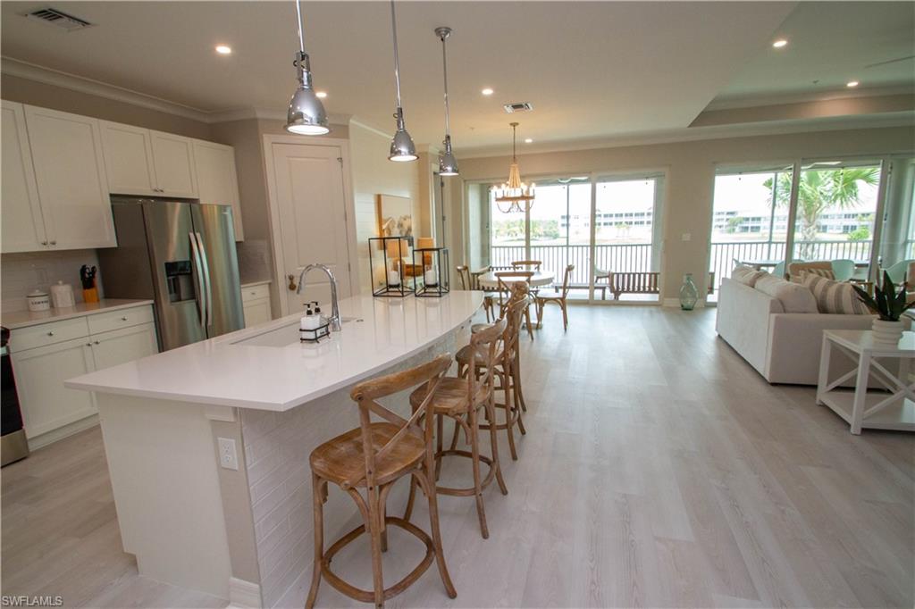 251 Indies Drive East, Unit 202 Naples, FL 34114 - Photo 9 of 48 a large kitchen with a table and chairs