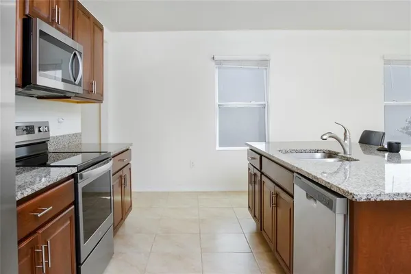 a kitchen with stainless steel appliances granite countertop a sink stove and cabinets