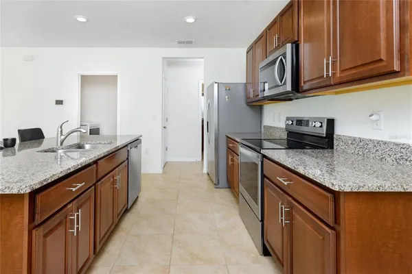 a kitchen with stainless steel appliances granite countertop a sink stove and refrigerator