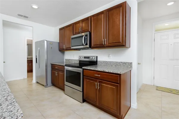 a kitchen with stainless steel appliances granite countertop a refrigerator stove and microwave
