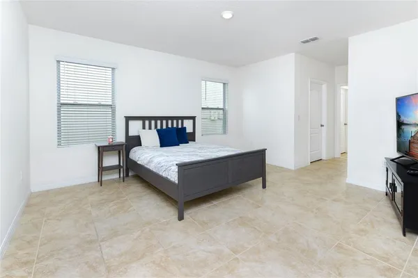 a bedroom with a bed and a flat tv screen on wall