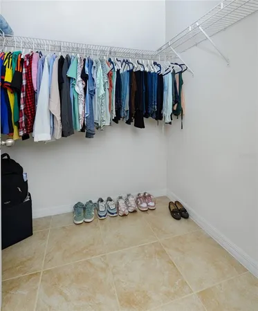 a view of walk in closet with clothes and shoes