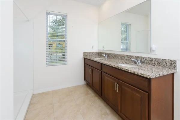 a bathroom with a granite countertop sink and a mirror
