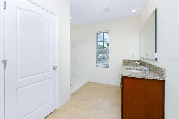 a bathroom with a granite countertop sink a toilet and shower