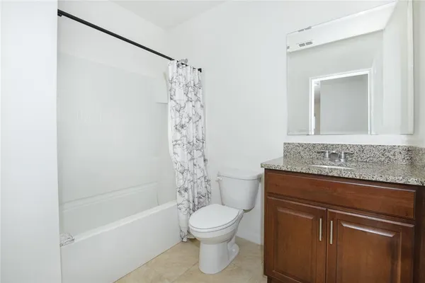 a bathroom with a granite countertop sink a toilet and a bathtub