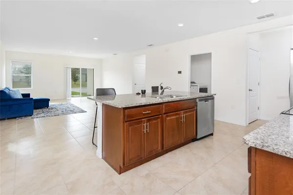a spacious bathroom with a granite countertop sink a mirror and a bathtub