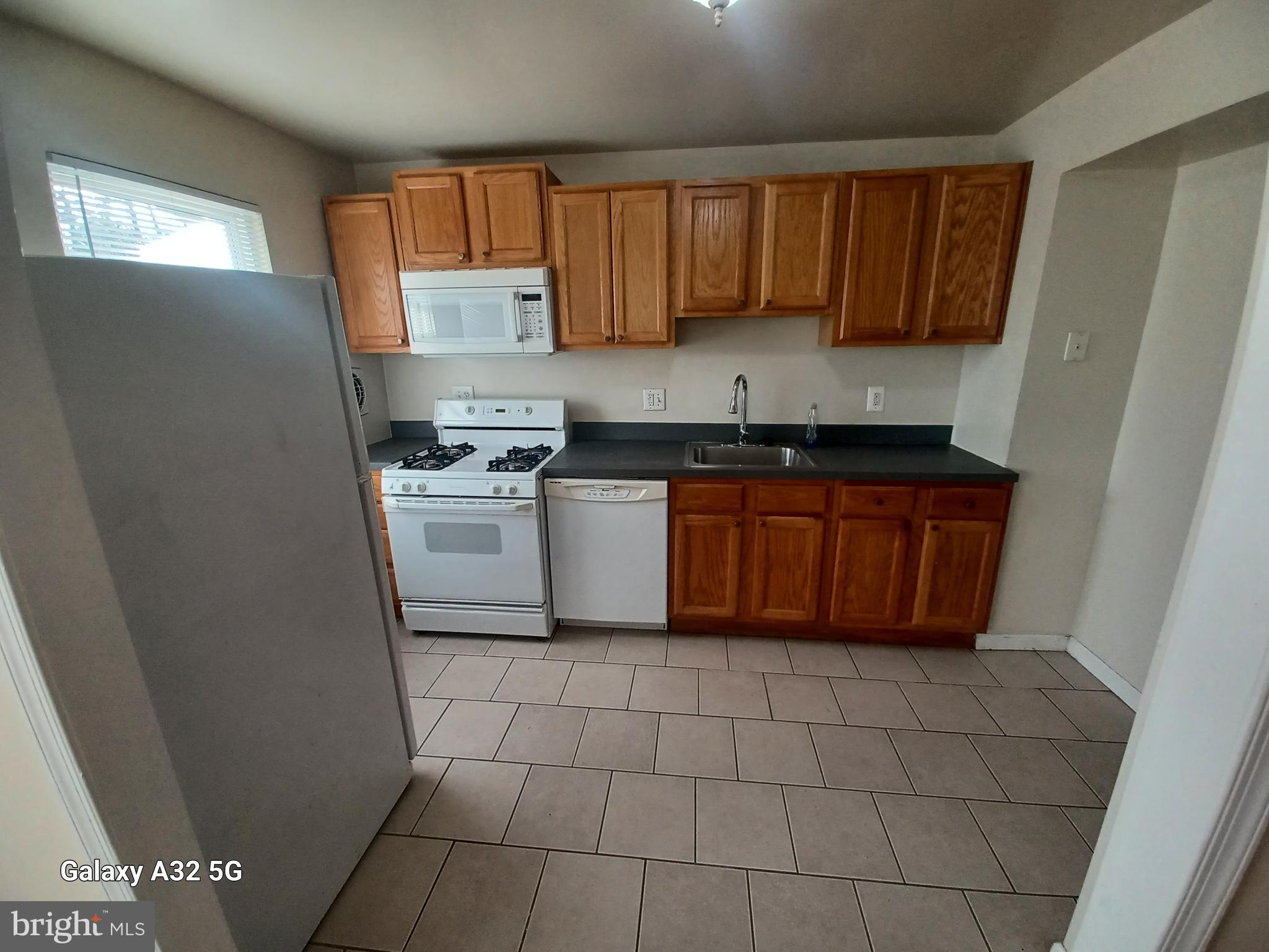 8213 Coatsbridge Court Severn, MD 21144 - Photo 6 of 19 a kitchen with stainless steel appliances a sink a stove a microwave a refrigerator a window and cabinets