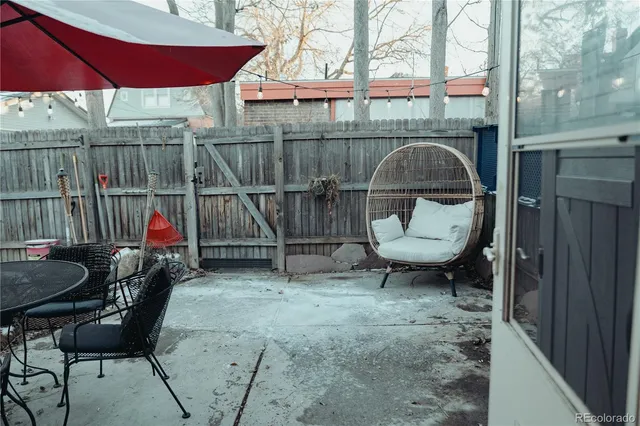 a view of a backyard with table and chairs potted plants