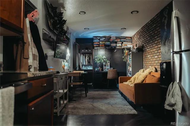 a living room with furniture a flat screen tv and kitchen view