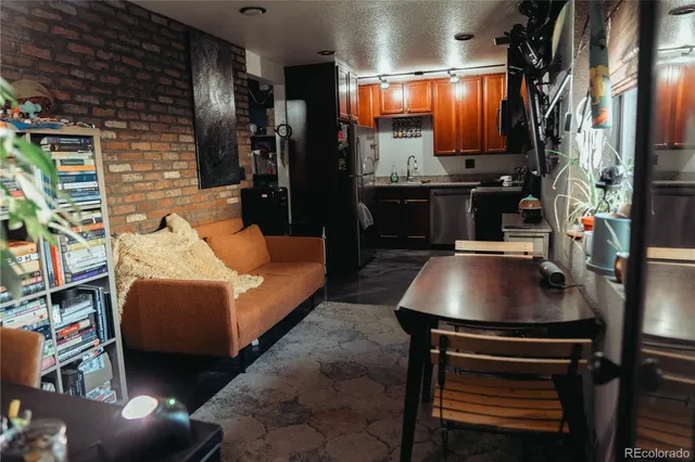 a kitchen with stainless steel appliances granite countertop a refrigerator a stove a sink and dishwasher with wooden floor