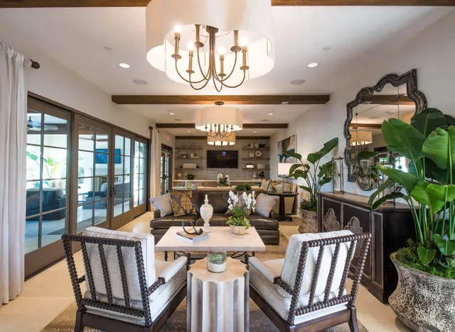 a living room with couches a fireplace and a dining table with garden view