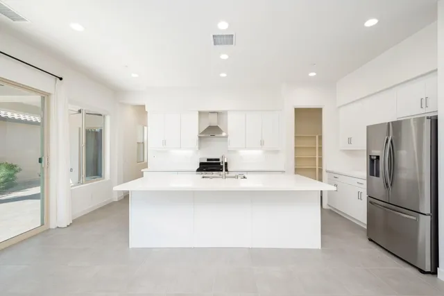 a large white kitchen with a large window