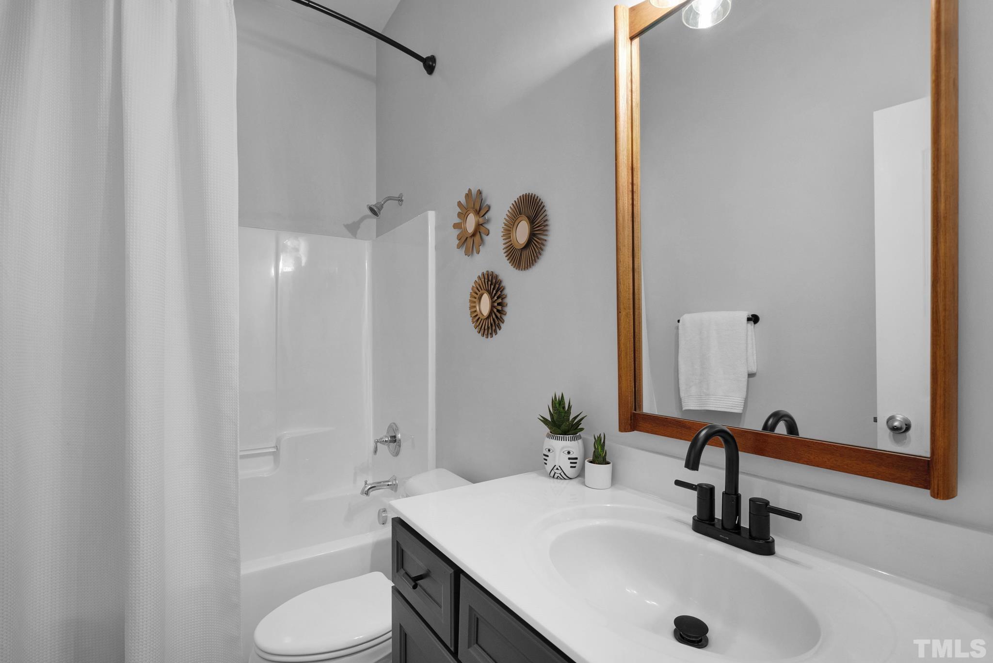 907 Chapanoke Road Raleigh, NC 27603 - Photo 11 of 26 a bathroom with a sink a toilet and shower