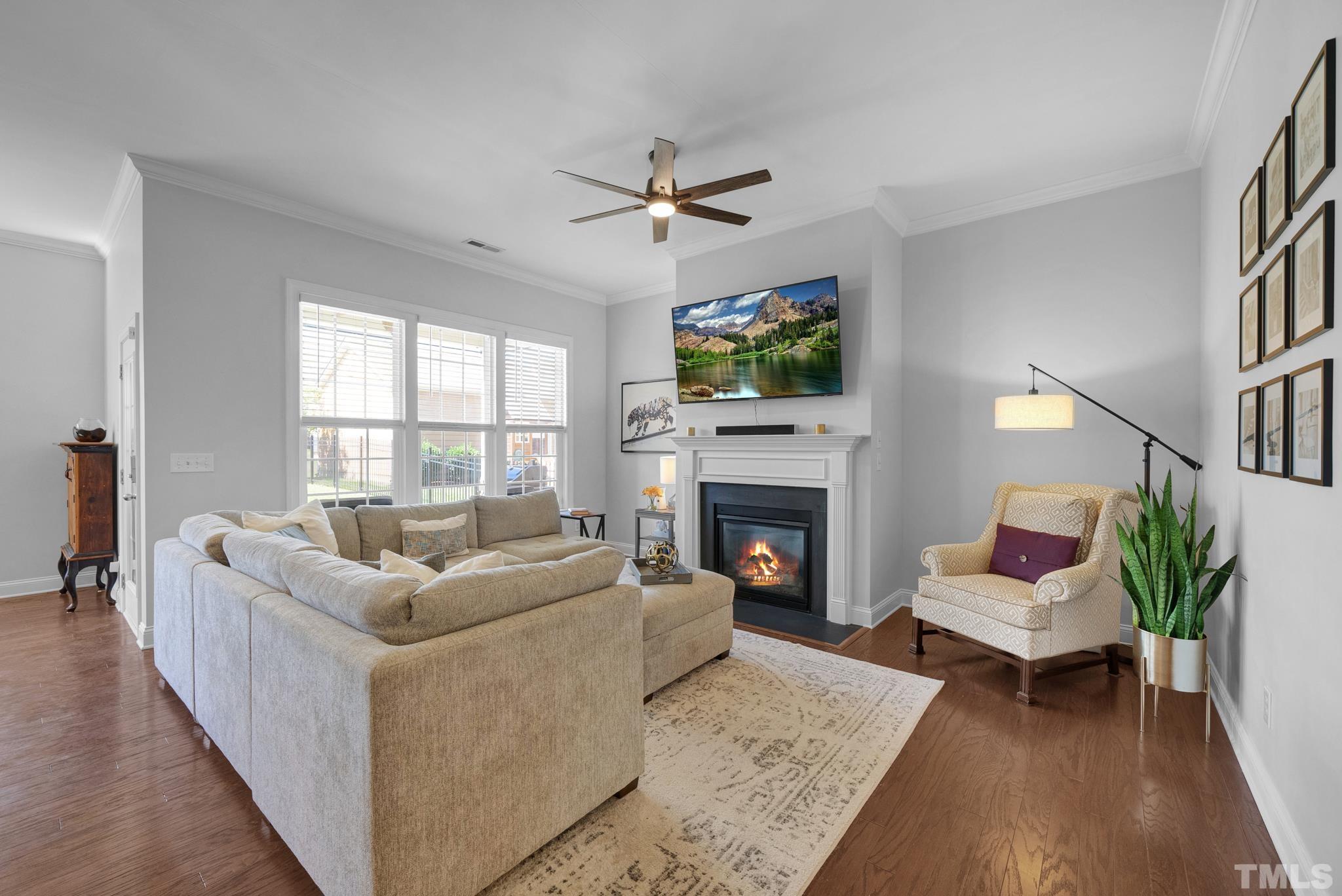907 Chapanoke Road Raleigh, NC 27603 - Photo 6 of 26 a living room with furniture a fireplace and a flat screen tv