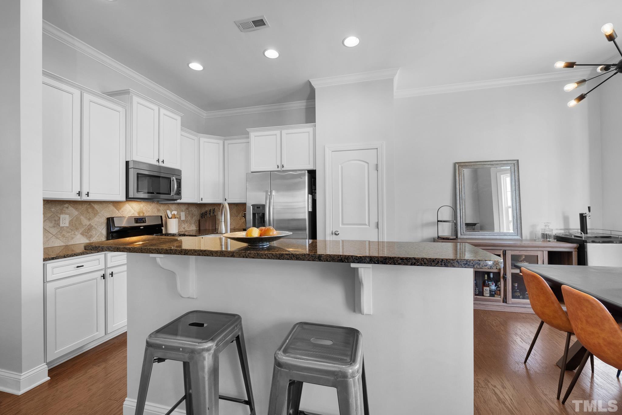 907 Chapanoke Road Raleigh, NC 27603 - Photo 8 of 26 a kitchen with stainless steel appliances a sink a stove a table and chairs