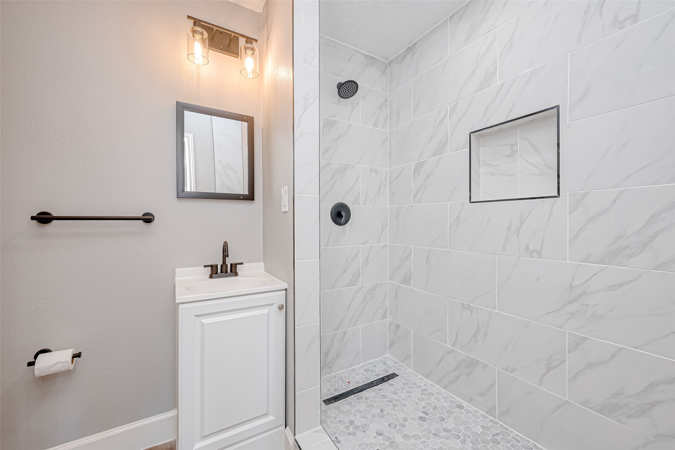 6715 Victoria Street Houston, TX 77020 - Photo 22 of 46 a bathroom with a shower a sink and mirror