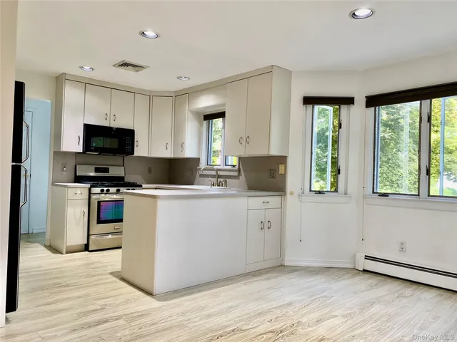 a kitchen with stainless steel appliances granite countertop a stove top oven a sink dishwasher a refrigerator and a microwave