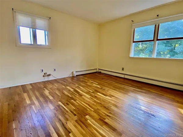 a view of a room with wooden floor and a window