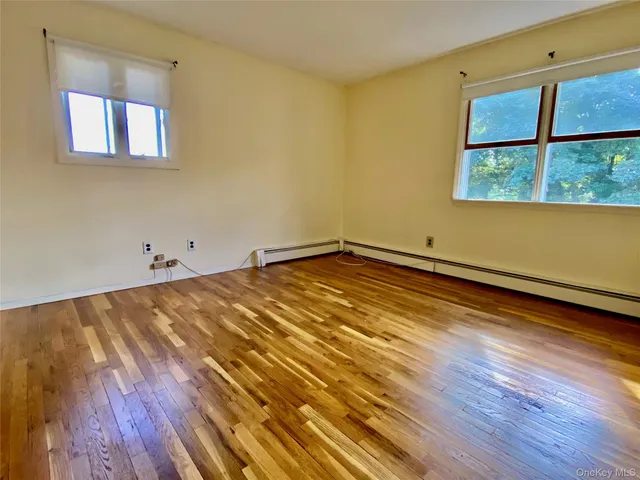 a view of a room with wooden floor and a window