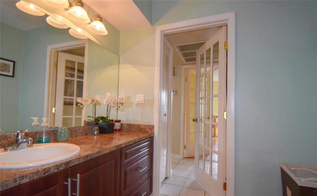 1748 Northwest 74th Avenue, Unit 19 Plantation, FL 33313 - Photo 24 of 44 a bathroom with a granite countertop sink a toilet and a mirror