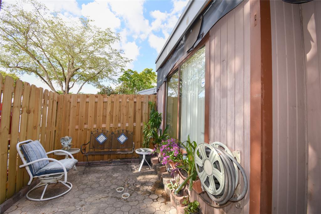 1748 Northwest 74th Avenue, Unit 19 Plantation, FL 33313 - Photo 3 of 44 a backyard of a house with barbeque oven table and chairs