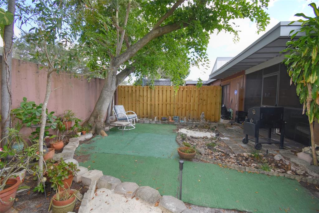 1748 Northwest 74th Avenue, Unit 19 Plantation, FL 33313 - Photo 39 of 44 a view of backyard with potted plants and a large tree