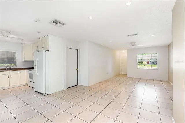a view of a kitchen with white cabinets and refrigerator