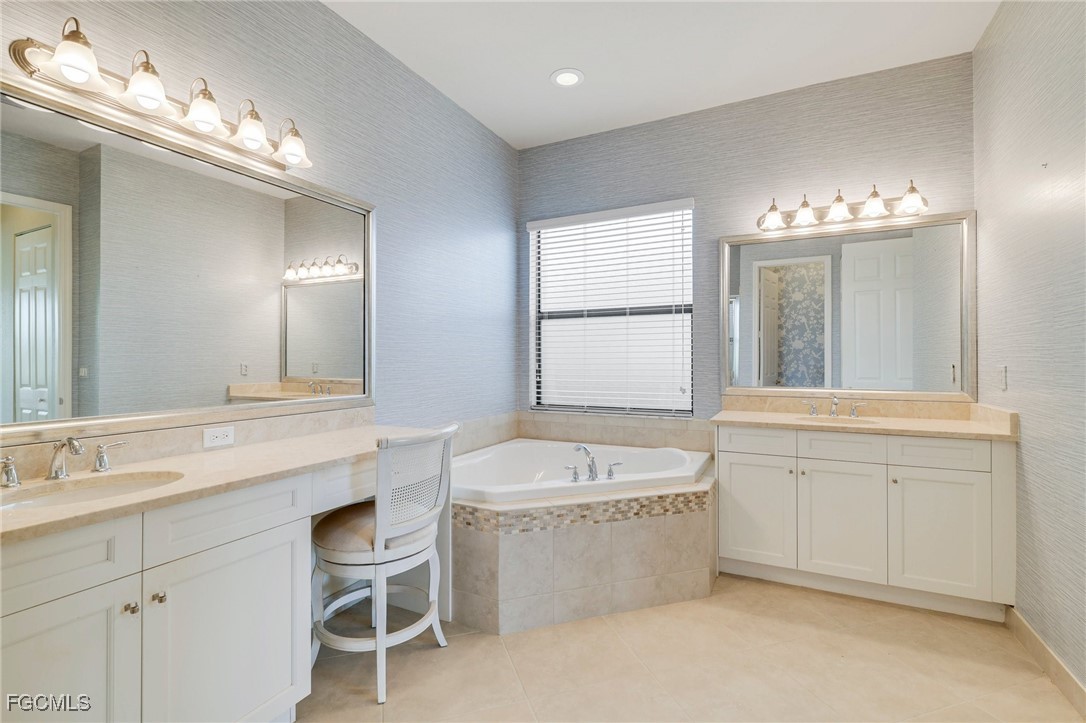 11643 Meadowrun Circle Fort Myers, FL 33913 - Photo 16 of 39 a bathroom with a tub a sink double vanity and a mirror