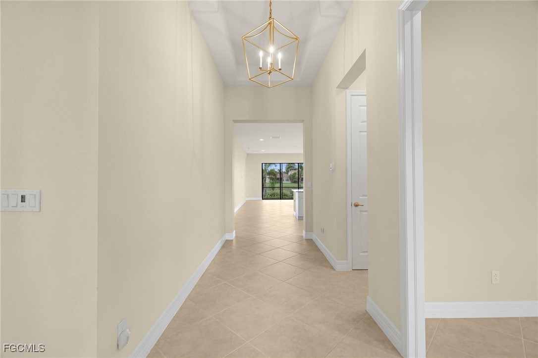 11643 Meadowrun Circle Fort Myers, FL 33913 - Photo 5 of 39 a view of a hallway with wooden floor and a chandelier