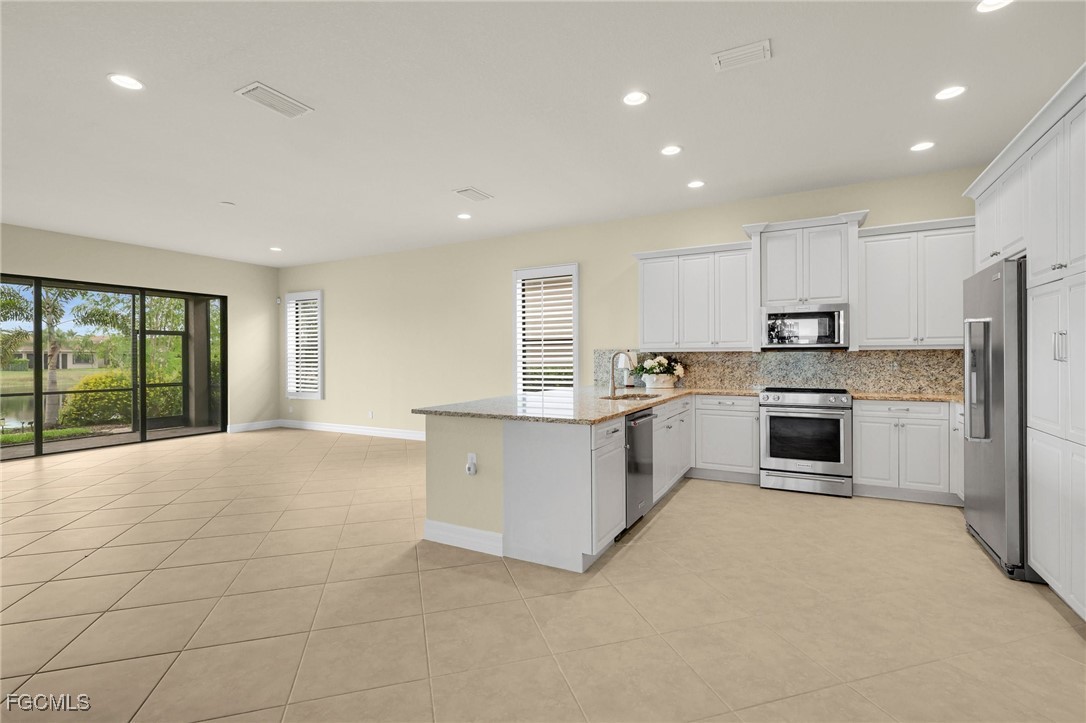 11643 Meadowrun Circle Fort Myers, FL 33913 - Photo 8 of 39 a large kitchen with a stove top oven and cabinets