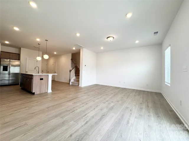 a view of a kitchen with a sink wooden cabinets and a window