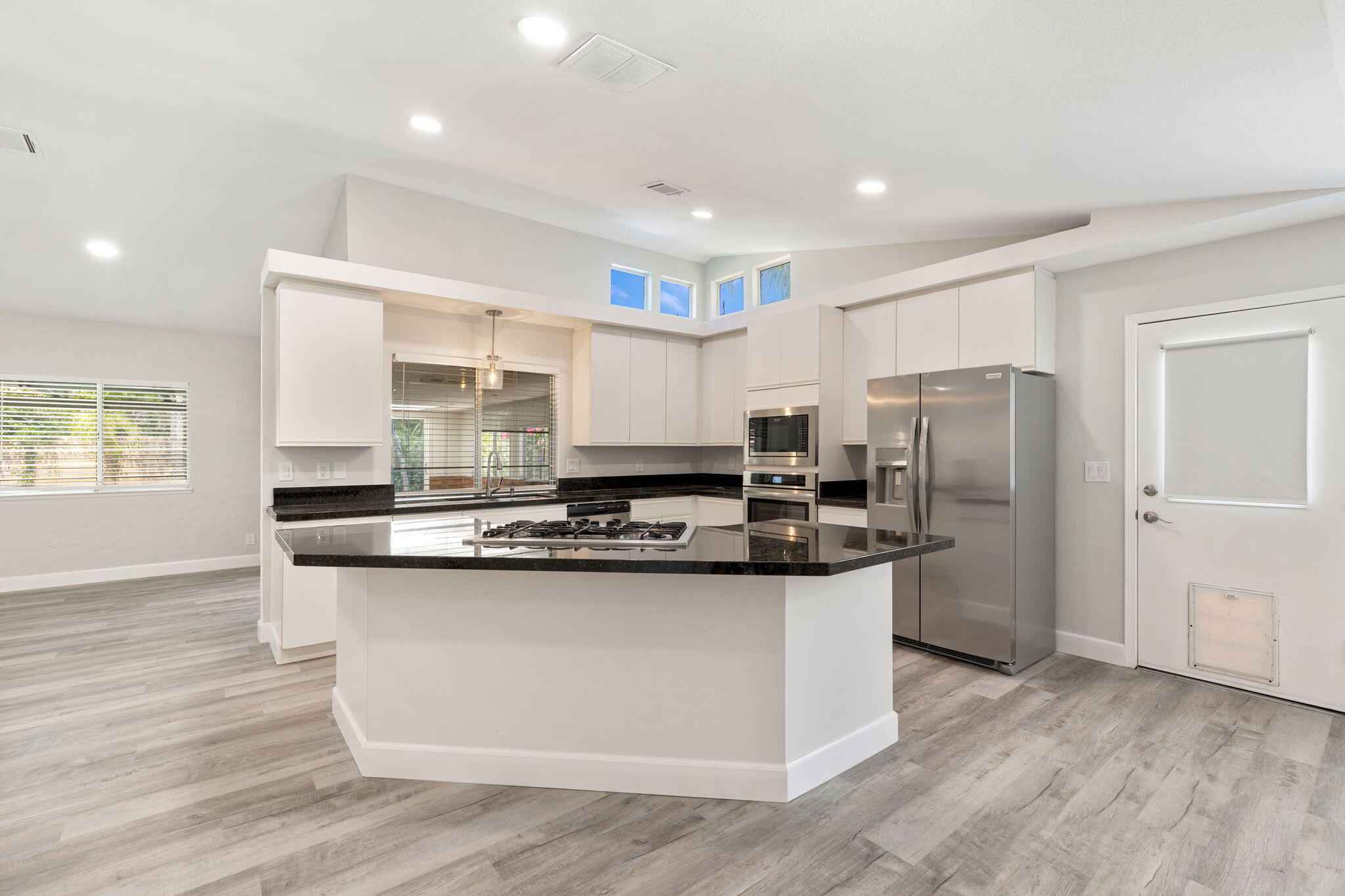 39495 Regency Way Palm Desert, CA 92211 - Photo 13 of 55 a kitchen with stainless steel appliances granite countertop a stove top oven a refrigerator a sink and dishwasher with wooden floor