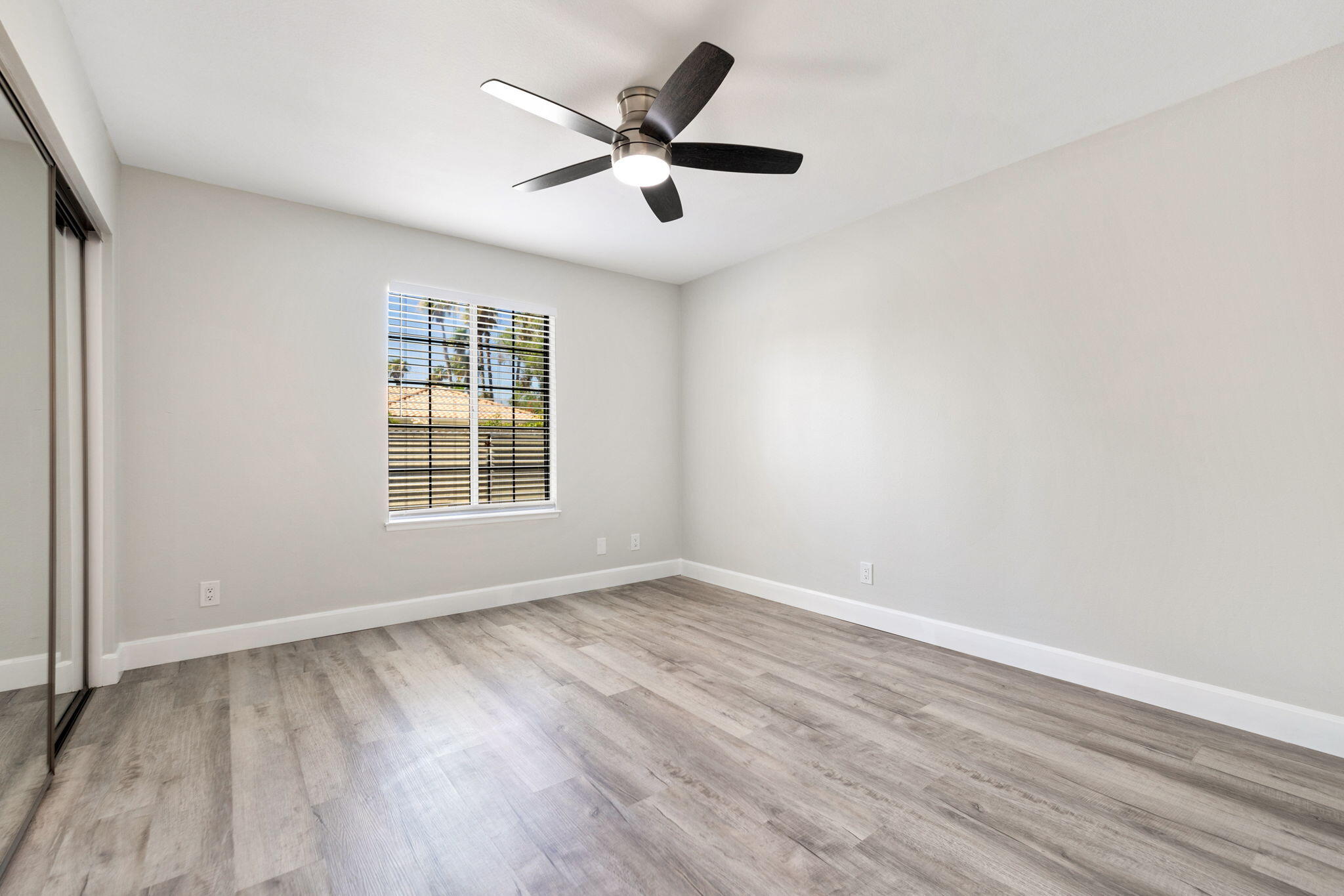 39495 Regency Way Palm Desert, CA 92211 - Photo 22 of 55 an empty room with wooden floor and windows