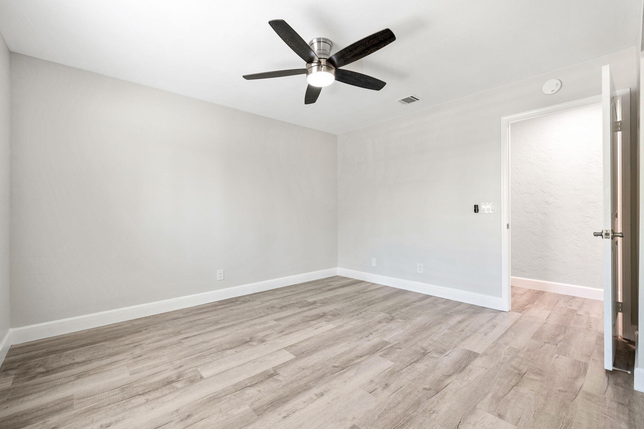 39495 Regency Way Palm Desert, CA 92211 - Photo 23 of 55 an empty room with wooden floor and ceiling fan