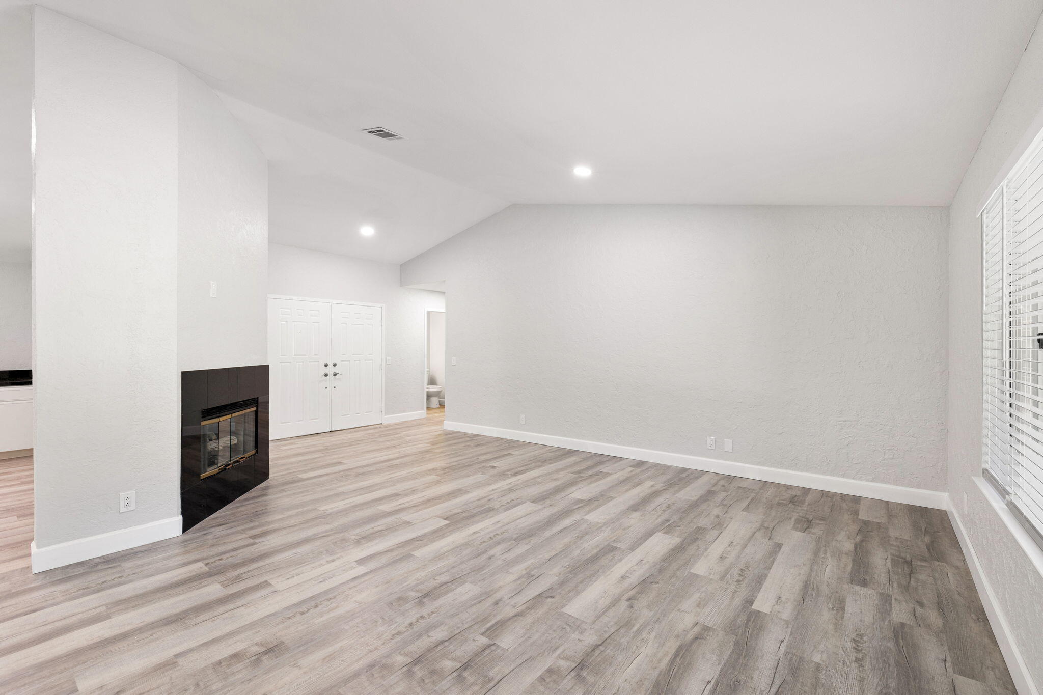 39495 Regency Way Palm Desert, CA 92211 - Photo 4 of 55 an empty room with wooden floor and fireplace
