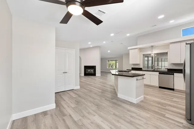 a kitchen with stainless steel appliances granite countertop a sink refrigerator and cabinets