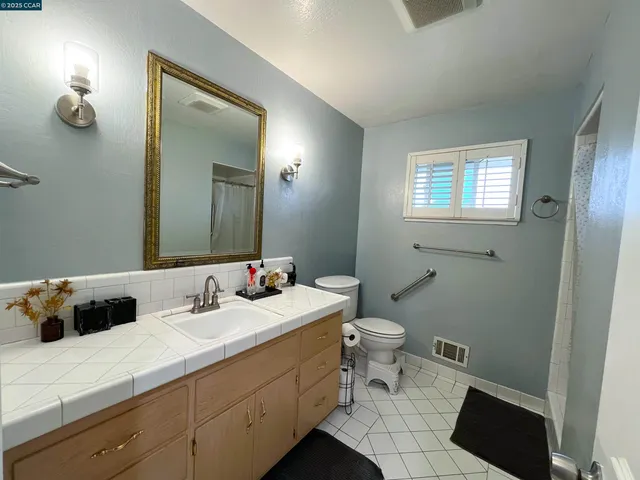 a bathroom with a sink a toilet and mirror