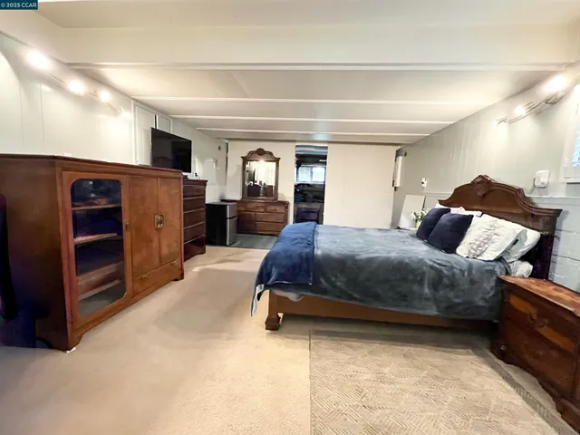 a spacious bedroom with a bed and a dresser