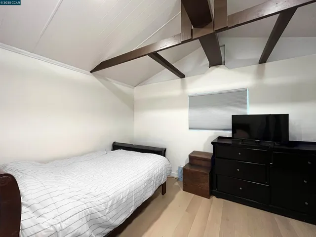a bedroom with a bed and a flat tv screen