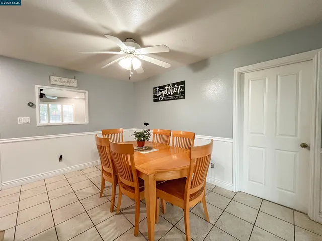 a view of a dining room with furniture and chandelier fan
