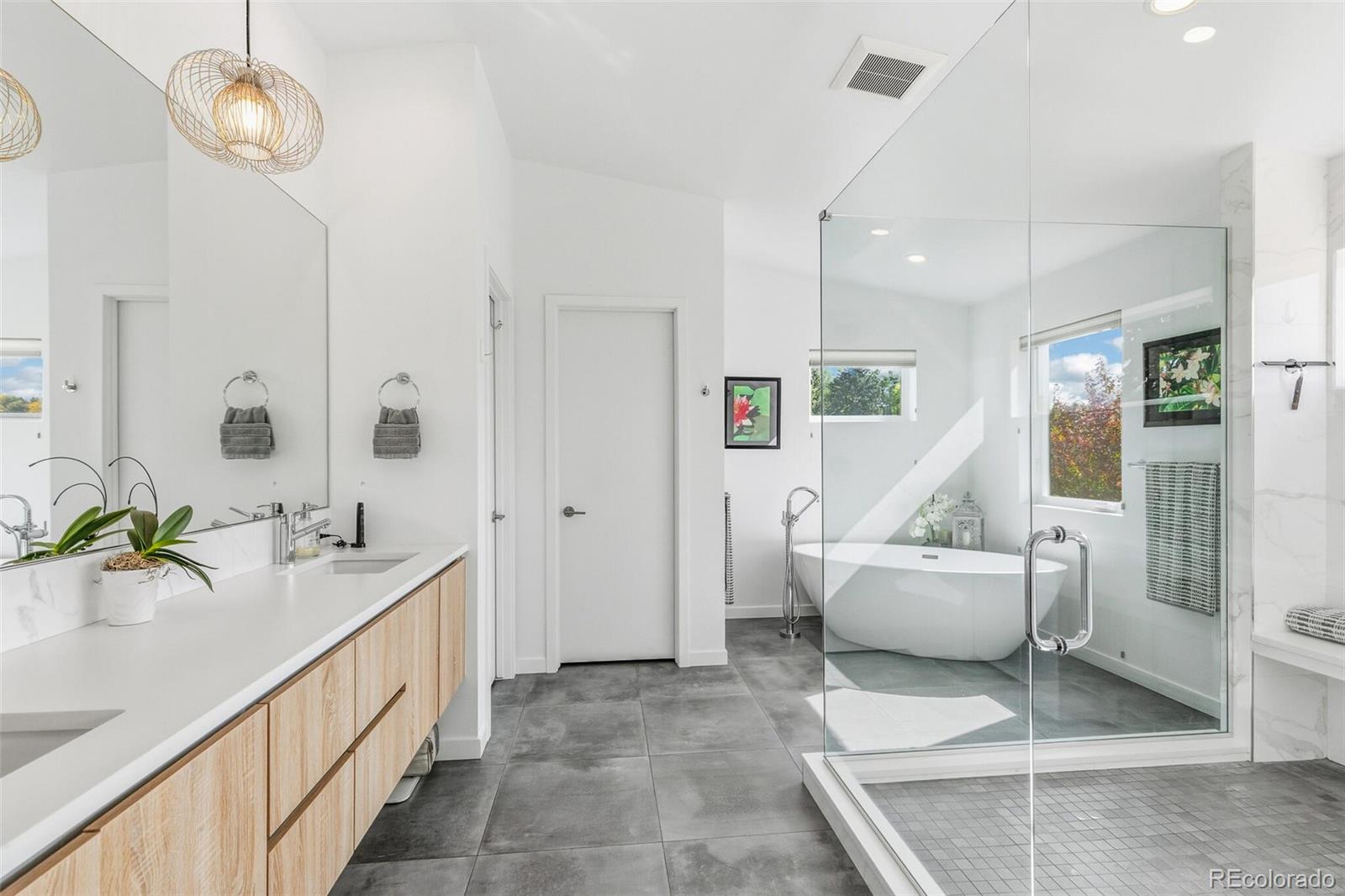 4077 Everett Street Wheat Ridge, CO 80033 - Photo 32 of 50 a bathroom with a granite countertop sink and a large mirror