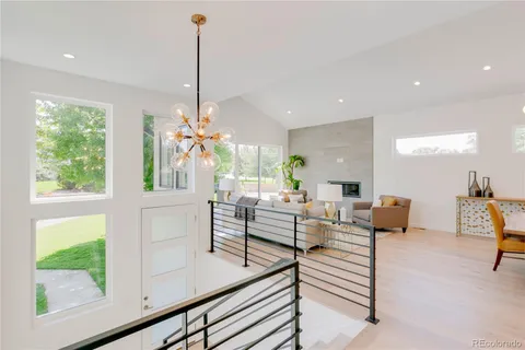 a living room with furniture a fireplace and a chandelier