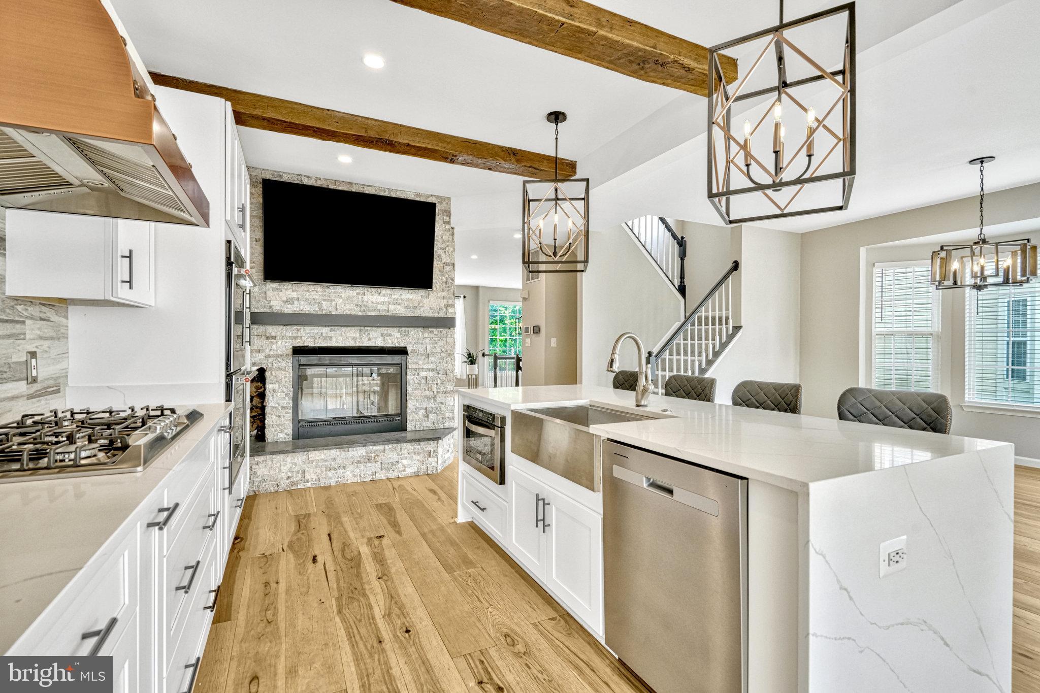 42751 Bennett Street Chantilly, VA 20152 - Photo 20 of 61 a open kitchen with a sink and a stove top oven with wooden floor