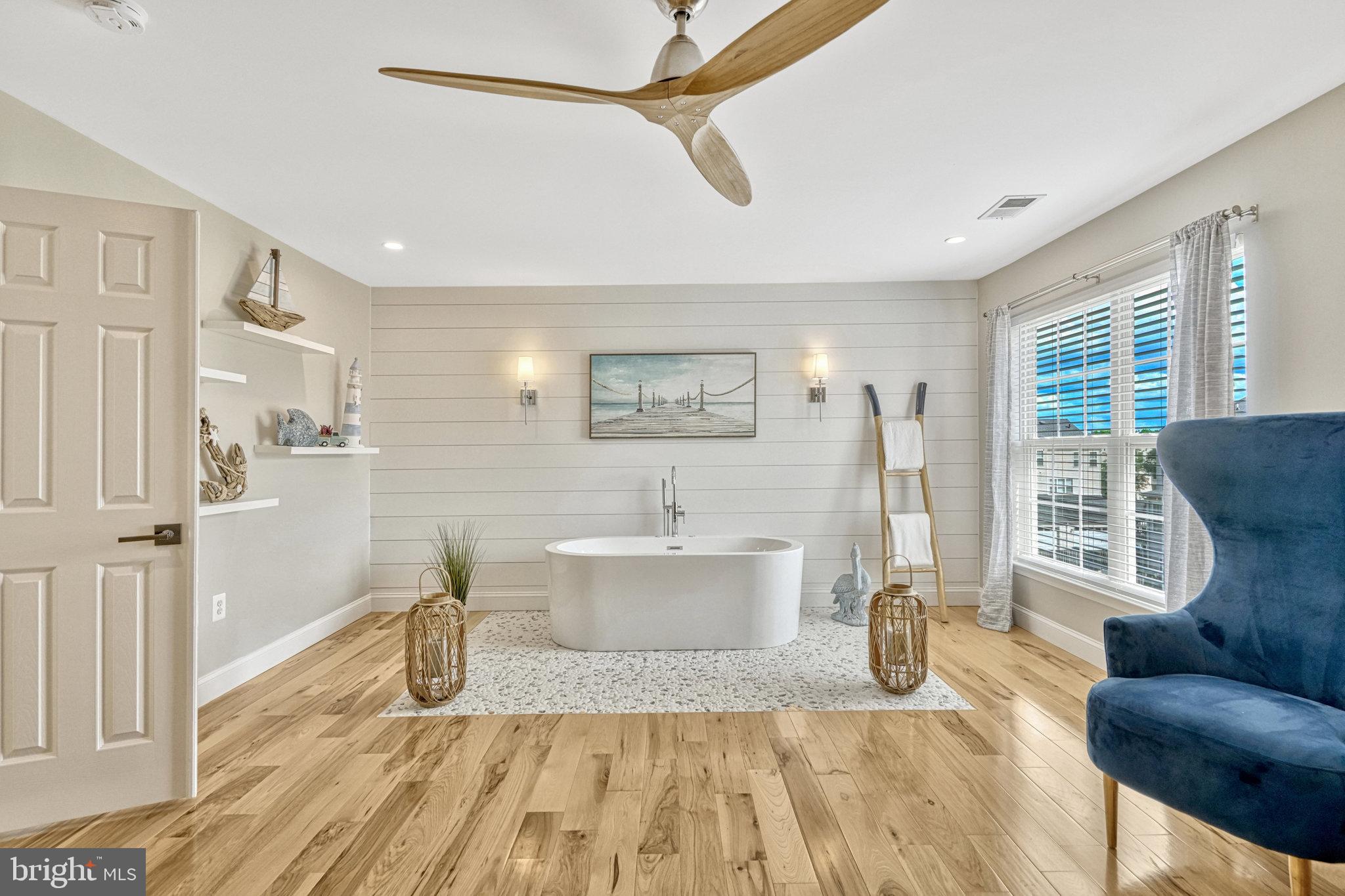 42751 Bennett Street Chantilly, VA 20152 - Photo 28 of 61 a spacious bedroom with a bed a couch and large window with wooden floor