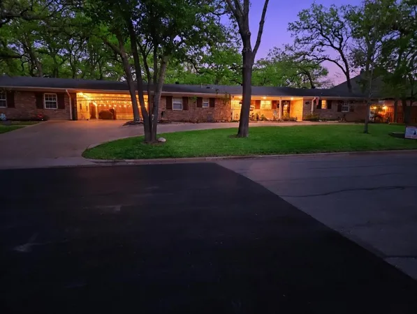 a front view of a house with a garden and tree