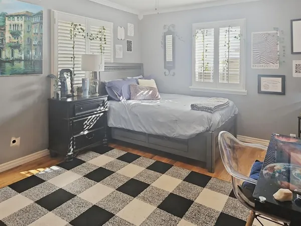 a bedroom with a bed and wooden floor